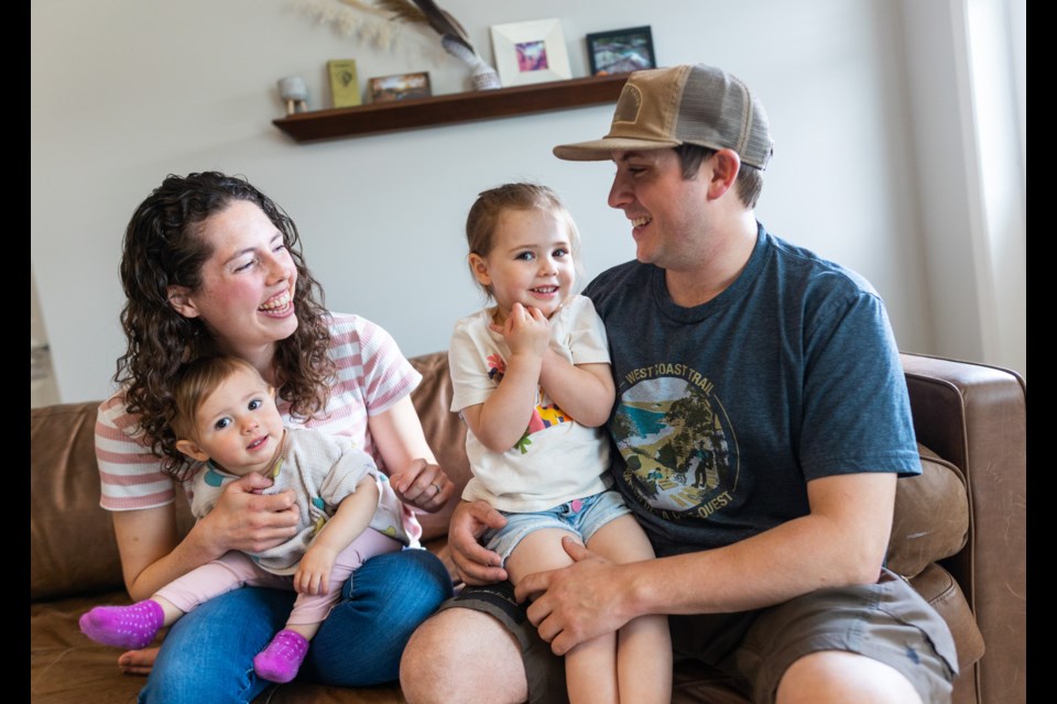 Michelle and Jesse Hebenton in their living room with daughters Heyden (right) and Lily. Two-year-old Heyden was diagnosed with Type-1 Diabetes a year ago and the family is concerned after learning of the UCP government potentially cancelling funding for the insulin pumps she uses.